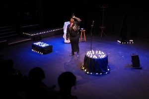 an image of Yvonne on stage in bedford surrounded by candles singing